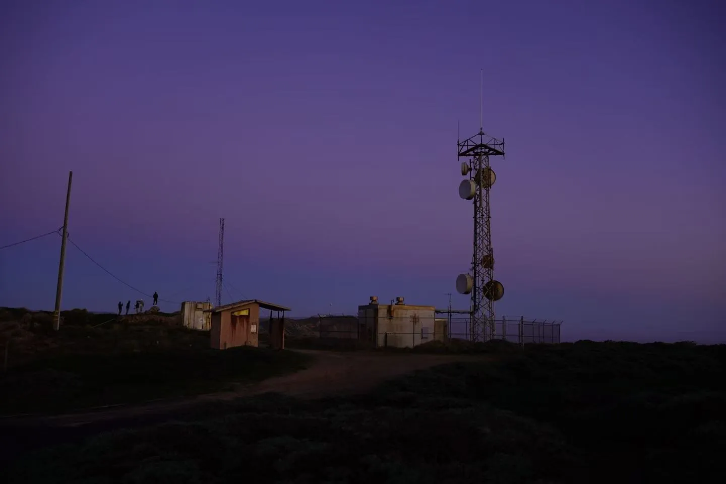 A radio tower on the headland after sunset